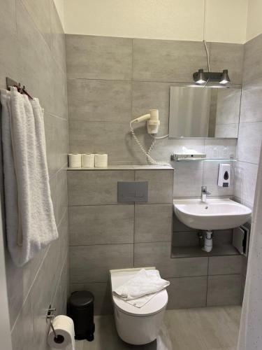 a bathroom with a sink and a toilet and a mirror at Hotel Skandia in Helsingør