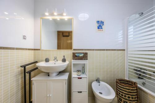 een badkamer met een wastafel, een toilet en een spiegel bij Blue Star Villa in Lajares