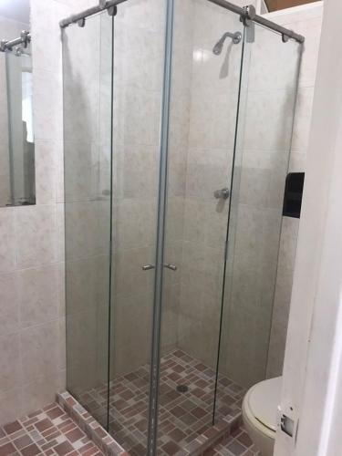 cabina de ducha de cristal con aseo en el baño en San Alejo en Tuluá