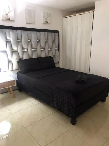 a large bed with a large headboard in a room at San Alejo in Tuluá