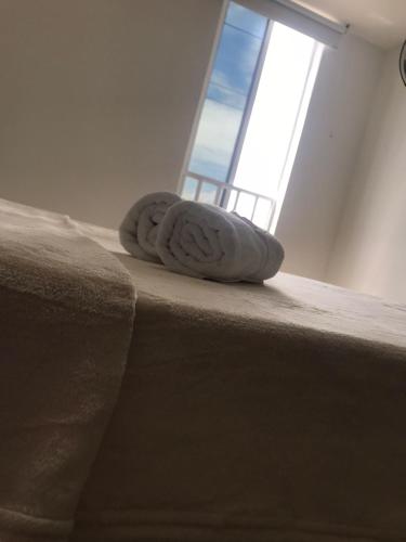 a pillow sitting on the edge of a bed with a window at San Alejo in Tuluá