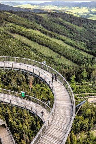 a walkway over a hill with people walking on it at Apartamenty Wakacyjne Historie in Międzylesie
