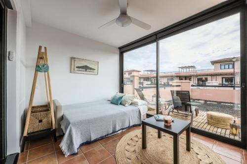 een slaapkamer met een bed en een groot raam bij Blue Star Villa in Lajares
