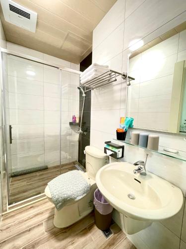 a bathroom with a sink and a toilet and a shower at Banshan Yunxiu Homestay in Jinning