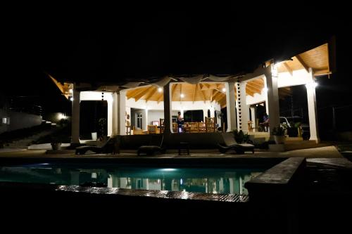 a house with a swimming pool at night at Hotel Don Bululo Camping Lodge in Punta Rucia