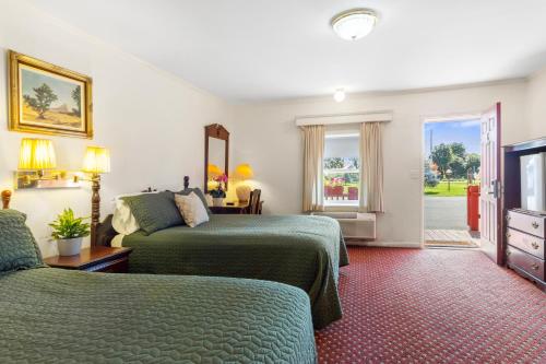 a hotel room with two beds and a television at Blue Spruce Inn & Suites in Valatie