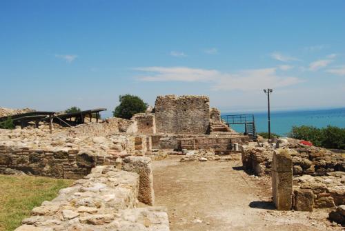 an ancient ruins with the ocean in the background at Hotel Achillion in Makrýgialos