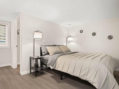 1 dormitorio blanco con 1 cama grande y 2 lámparas en Elegant Richmond Gem nestled up to Hawthorne Blvd., en Portland