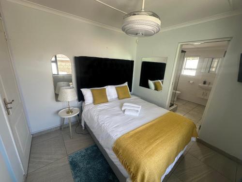 a bedroom with a large bed with a yellow blanket at The Legacy in East London