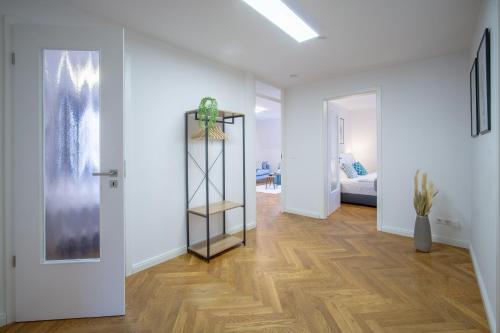 ドレスデンにあるCoView - ruhige Design Wohnung - 2 Schlafzimmer - voll ausgestattete Kücheの白い壁とウッドフロアの廊下