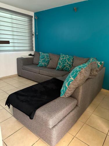 un sofá en una sala de estar con una pared azul en Alojamiento privado con seguridad 3, en Tepic