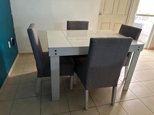 una mesa blanca con cuatro sillas alrededor en Alojamiento privado con seguridad 3, en Tepic