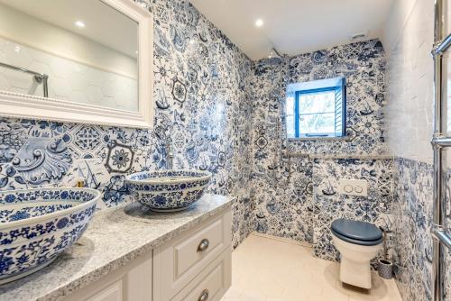 a blue and white bathroom with a toilet and a sink at Tabbs Cottage - Close To Salcombe and Beaches in Malborough