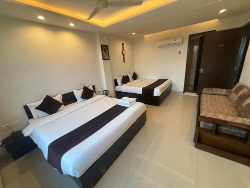 a hotel room with two beds and a couch at Hotel Life Inn in Jaipur