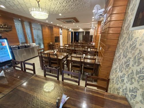 a restaurant with wooden walls and tables and chairs at Hotel Life Inn in Jaipur