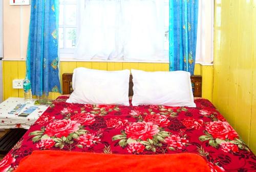 ダージリンにあるHotel New Smriya Homestay Inn Darjeelingの赤い毛布と赤いバラのベッド