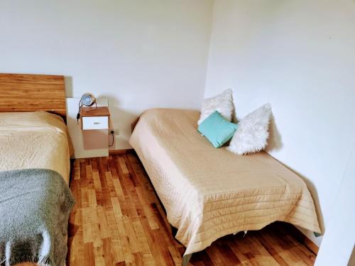1 dormitorio con 2 camas y suelo de madera en Centro RG en Río Gallegos