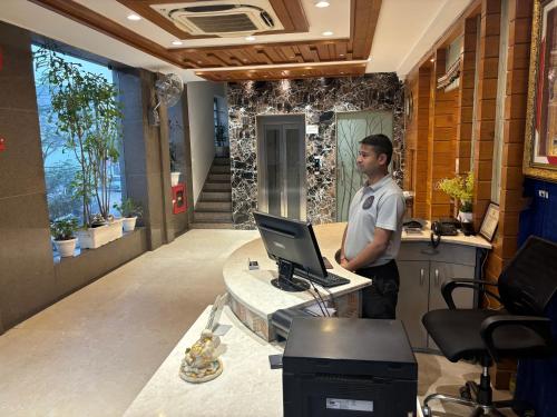 a man standing in front of a desk with a laptop at Hotel Life Inn in Jaipur