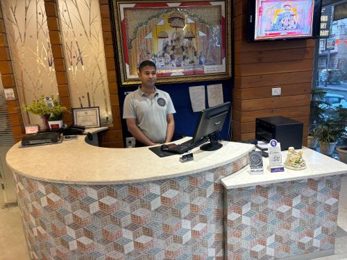 a man standing behind a counter with a computer at Hotel Life Inn in Jaipur