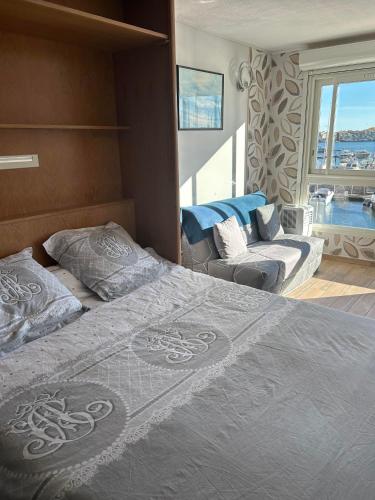 - une chambre avec un grand lit et un canapé dans l'établissement Studio cosy climatisé vue sur port, au Cap d'Agde
