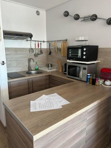 - une cuisine avec un comptoir en bois et un four micro-ondes dans l'établissement Studio cosy climatisé vue sur port, au Cap d'Agde