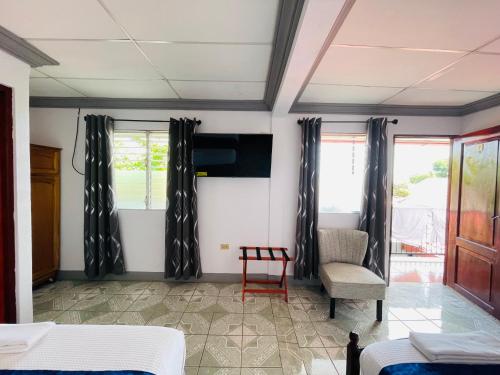 a room with two beds and a chair and windows at Hostal Clary in León