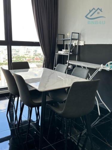 a table and chairs in a room with a window at Urban Suites Georgetown by BNB4U in Jelutong