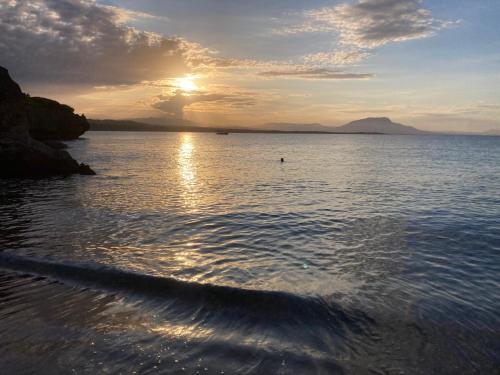 a sunset over a body of water with the sun setting at Cita del Sol City Apartments in Cabarete