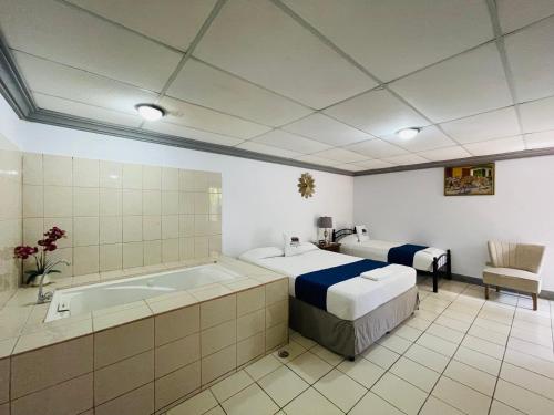 a bathroom with a tub and a bed and a bed and a bed at Hostal Clary in León