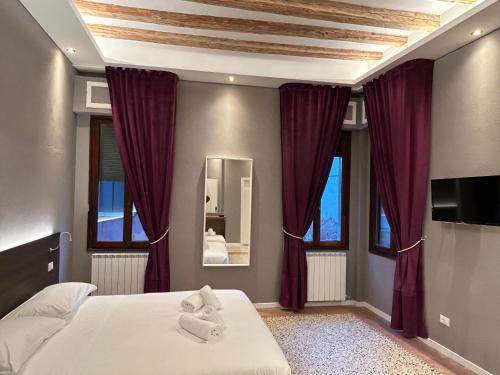 a bedroom with purple curtains and a bed and a mirror at Ca' Piasentin in Venice