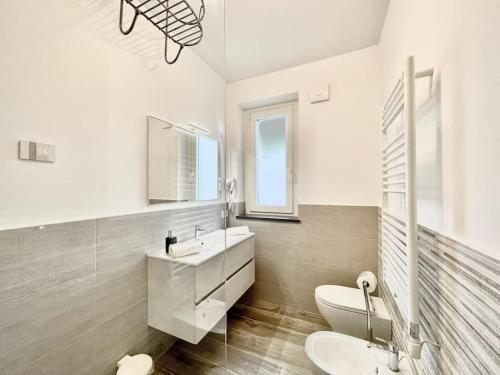 uma casa de banho com um lavatório, um WC e um espelho. em La Corte di Nonna Ada em Pianillo