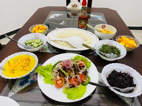 una mesa con platos de comida y tazones de comida en Udara Guest - Yala Safari en Yala