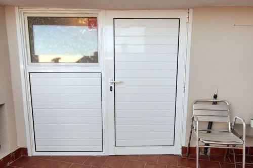 a white door with a window next to a chair at Apartamento entero en la montaña in El Pont de Vilomara