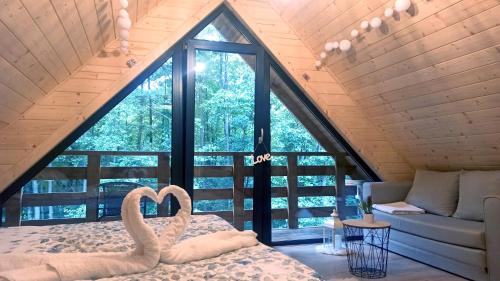 a room with two swans on a bed in front of a window at Las Lorien - wynajem domków letniskowych in Roczyny