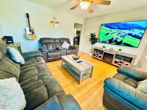 a living room with couches and a flat screen tv at Bright, Stylish & Cozy 2Bed Unit w/Backyard & Grill Close to NYC! in Haledon