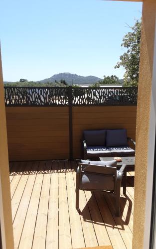 une terrasse couverte avec un canapé sur une terrasse en bois dans l'établissement Villa détente, à Ollioules