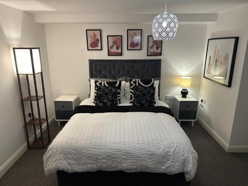 a bedroom with a large bed with black and white pillows at Margate Apartment in Kent