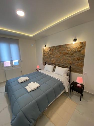 a bedroom with a large blue bed with two towels at Alexandra apartment in Athens