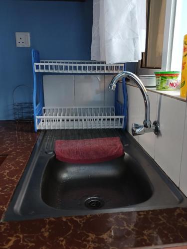 a kitchen sink with a red towel in it at J's Nest in Kericho