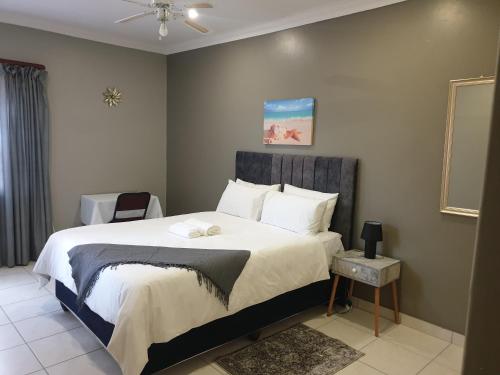 a bedroom with a large bed with white pillows at Grace Avenue Townhouse in Port Edward