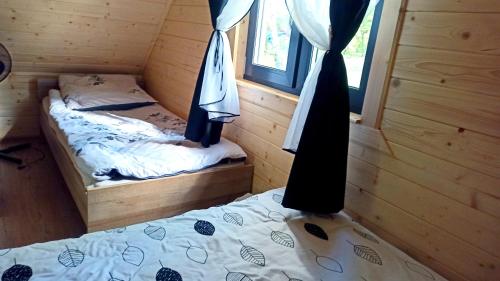 a bedroom with two twin beds in a cabin at Las Lorien - wynajem domków letniskowych in Roczyny