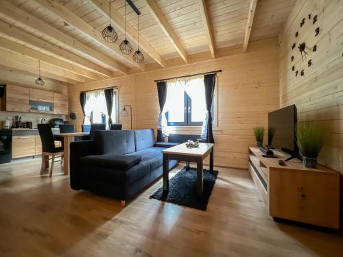 ein Wohnzimmer mit einem Sofa und einem Tisch in der Unterkunft Las Lorien - wynajem domków letniskowych in Roczyny
