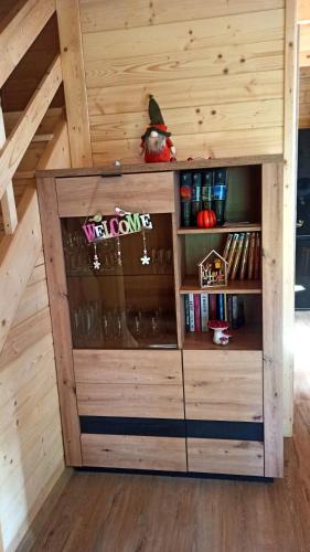 a wooden cabin with a book shelf in the attic at Las Lorien - wynajem domków letniskowych in Roczyny
