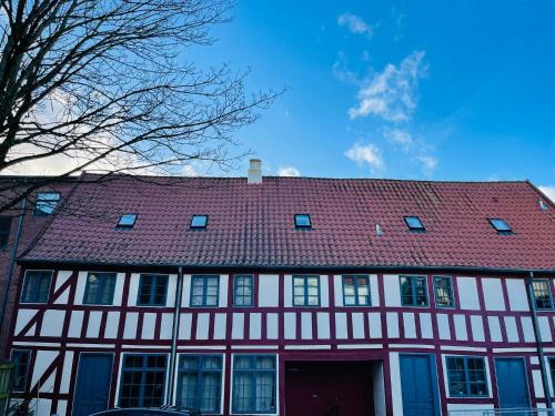 a red and white building with a red roof at Scandinavian Apartment Hotel - Tobaksgården Budget - 2 room apartment in Horsens
