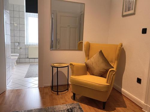 een woonkamer met een stoel en een spiegel bij Hotel Antoni in Bochum
