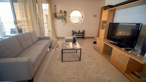 a living room with a couch and a flat screen tv at Mellieha Bay 3 Bedroom Apartment ''Coastal Comfort'' in Mellieħa