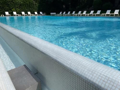 uma piscina com cadeiras e água azul em T2 avec Terrasse et Jardin em Cannes