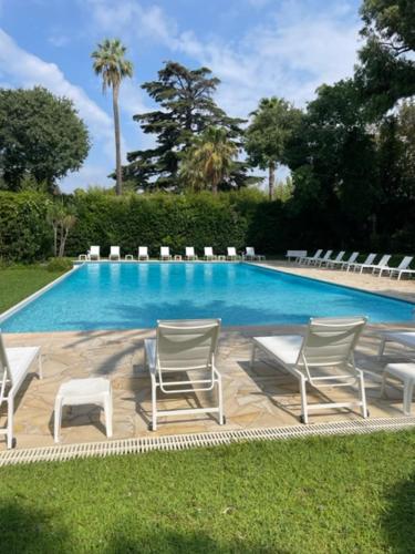 un groupe de chaises assises à côté d'une piscine dans l'établissement T2 avec Terrasse et Jardin, à Cannes