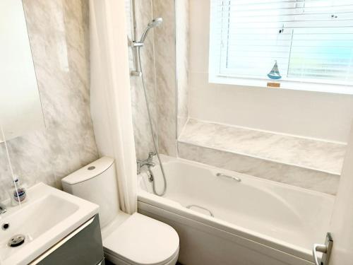 a bathroom with a toilet and a tub and a sink at 1 Bed Bognor Apartment 300 yrds from beach in Bognor Regis