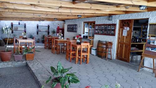 un restaurante con mesas de madera y sillas en una habitación en Hostal El Colibri en Vicuña